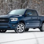 A popular Ram truck special edition, a blue 2020 Ram 1500 is parked on a snowy woodland road.