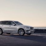 A silver 2021 Volvo XC90 is parked at a beach at dusk.