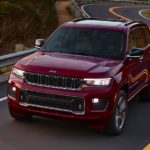 A red 2021 Jeep Grand Cherokee L is shown driving on a road after winning a 2021 Jeep Grand Cherokee L vs 2021 Dodge Durango face-off.