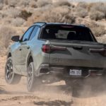 A grey 2022 Hyundai Santa cruise is shown from the rear while it drives off-road after leaving a Hyundai Dealer in Edmonton.