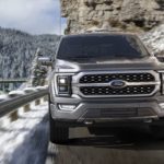 A grey 2022 Ford F-150 is shown from the front driving in the mountains during a 2022 Ford F-150 vs 2022 Nissan Titan comparison.