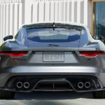 A grey 2022 Jaguar F-Type is shown from the rear on a city street.