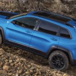 A blue 2022 Jeep Cherokee Trailhawk is shown from the side off-roading after leaving a Jeep dealer.