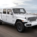 A white 2020 Jeep Gladiator is shown driving to a Jeep Gladiator dealer.