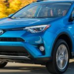 A blue 2016 Toyota RAV4 is shown driving on a road after viewing used SUVs for sale.