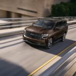 A brown 2022 Chevy Tahoe is shown from the front at an angle after leaving a Chevy dealership.