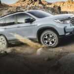 A grey 2023 Honda Passport Trailsport is shown from the side while off-road.