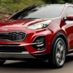 A red 2020 Kia Sportage for sale is shown driving on a road.