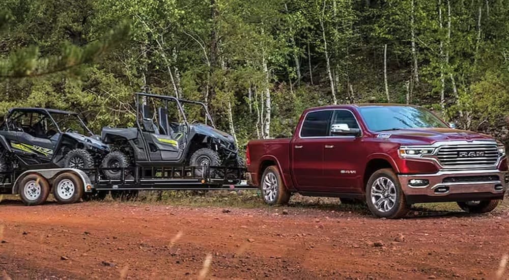A red Ram 1500 is shown towing a trailer.