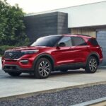 A red 2023 Ford Explorer ST-Line is shown parked on a driveway.