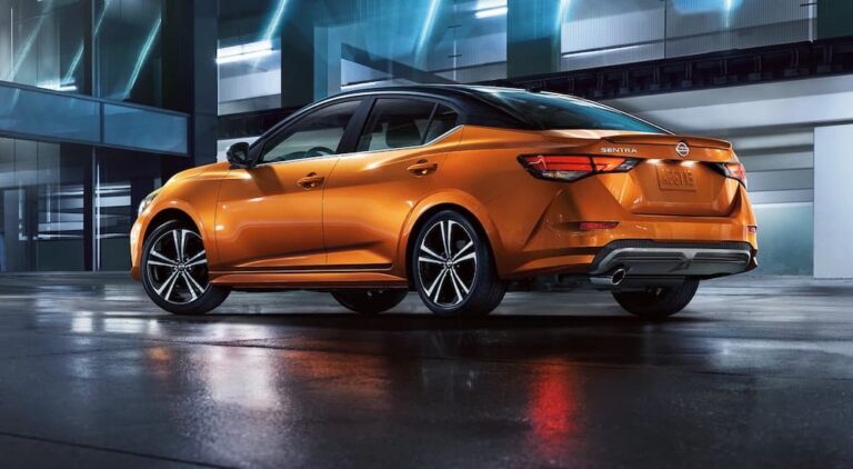 An orange 2023 Nissan Sentra is shown from the rear at an angle.