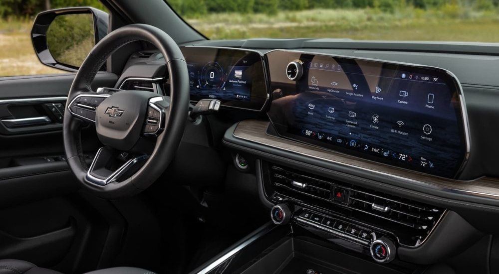 The black interior and infotainment screen are shown in a 2025 Chevy Suburban.