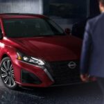 A red 2024 Nissan Altima SL is shown parked next to a person wearing a blue jacket.