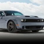 A gray 2023 Dodge Challenger SRT is shown parked on sand.