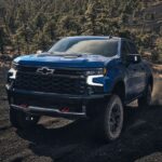 A popular Chevy Silverado for sale, a blue 2024 Chevy Silverado ZR2 is shown driving off-road.