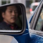 A man is shown looking into a mirror while it flashes a safety warning.