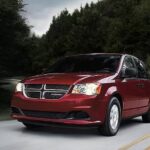 A red 2020 Dodge Grand Caravan is shown driving on a highway.