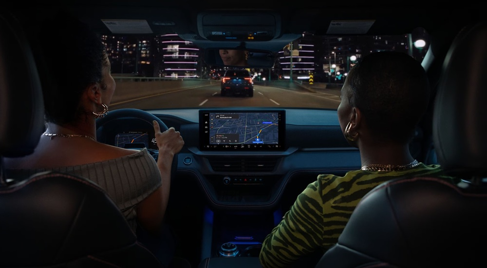 Two women driving in a 2025 Ford Explorer with the Ford Digital Experience infotainment system.