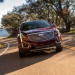 A red 2018 Cadillac XT5 driving from a front angle.