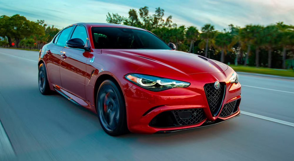 A red 2024 Alfa Romeo Giulia driving on the highway.