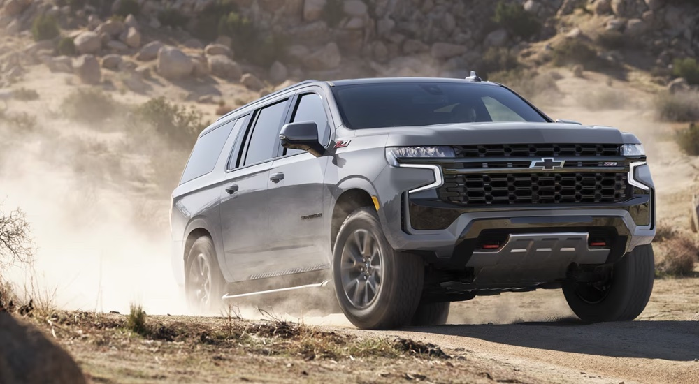 A silver 2024 Chevy Suburban Z71 kicking up dust while off-roading.