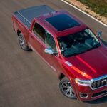 A red 2025 Ram 1500 Tungsten parked on a road.