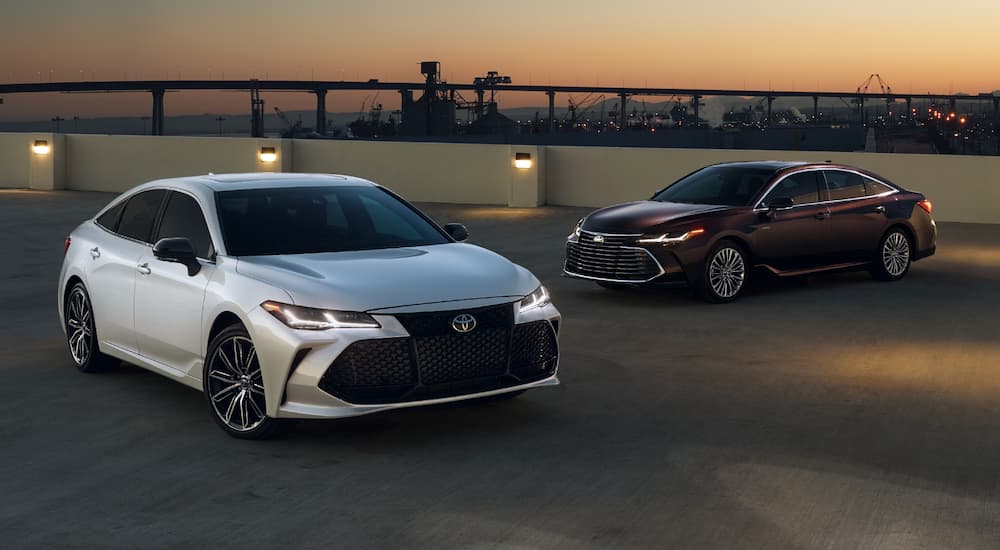 Two 2020 Toyota Avalons, one maroon and one white, parked on a city rooftop.