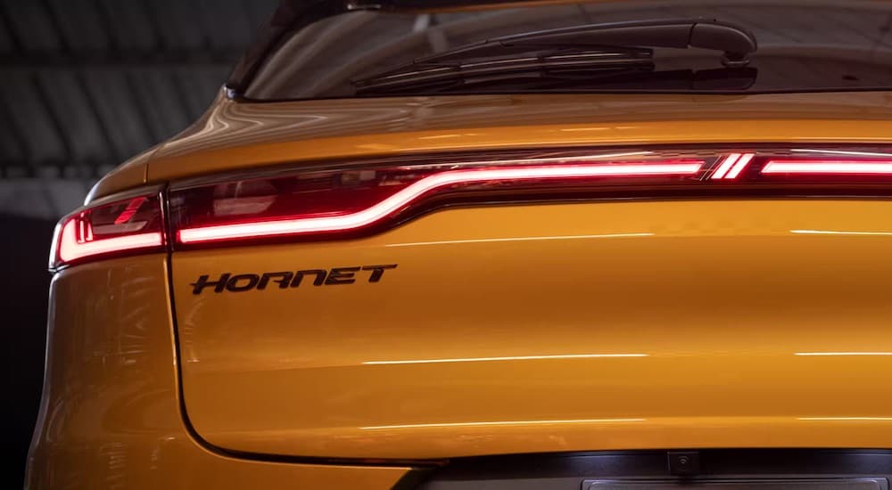 The rear of a gold 2024 Dodge Hornet is shown in close-up.