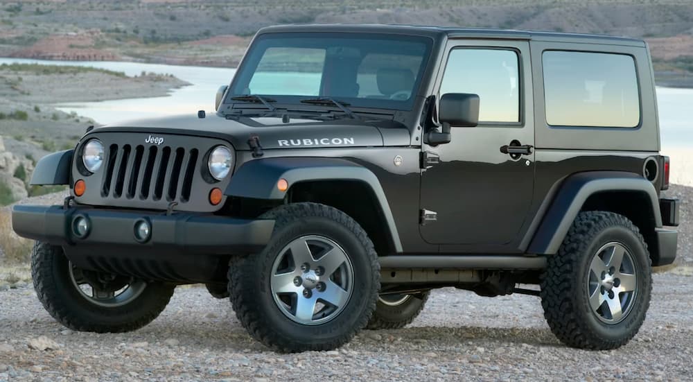 A black 2010 Jeep Wrangler Rubicon is shown parked near a body of water.