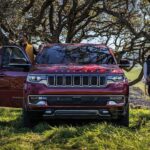 A front view of a red 2024 Wagoneer driving on a trail.