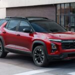 A red 2025 Chevy Equinox RS is shown stopped at a crosswalk before viewing a Chevy Equinox for sale.