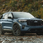 A blue 2025 Ford Explorer ST parked in an open clearing.