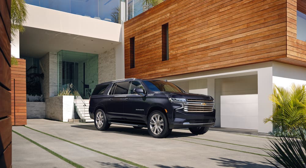 A black 2024 Chevy Suburban is shown from the front at an angle after leaving a Chevy dealer.