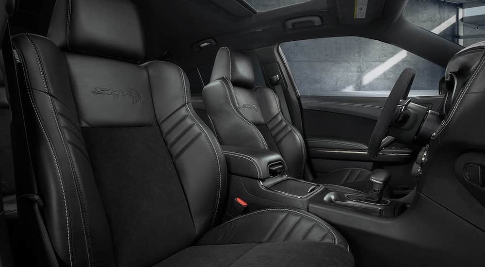 The black interior of a 2022 Dodge Charger SRT Hellcat is shown from the passenger seat.