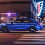 Side angle view of a blue 2025 Honda Civic Hybrid driving in a city from a Honda dealer.