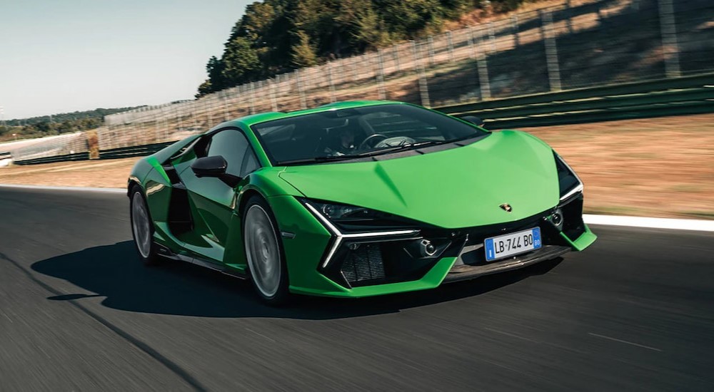 A green 2024 Lamborghini Revuelto is shown driving on a racetrack.