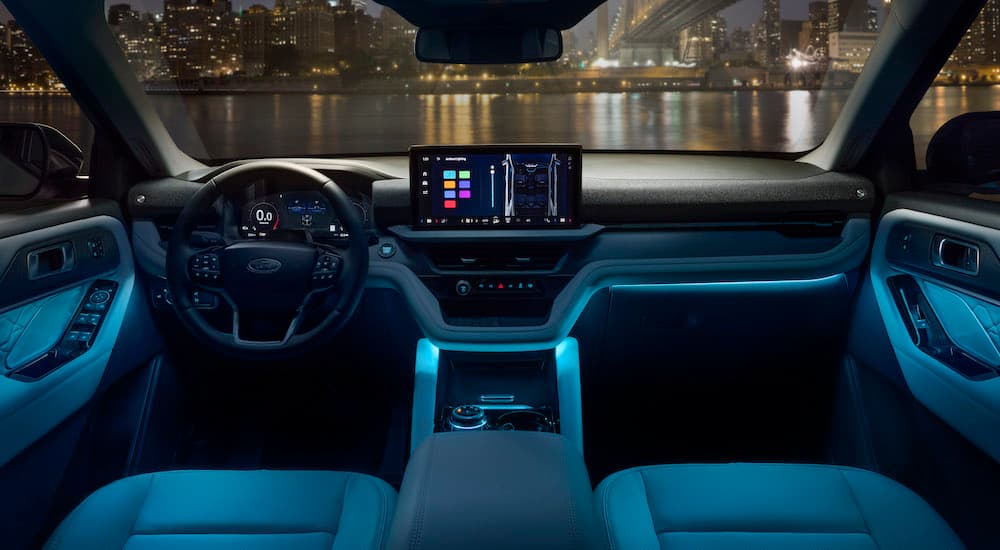 The blue-lit interior of a 2025 Ford Explorer for sale is shown from above the center console.