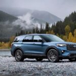 A blue 2025 Ford Explorer ST is shown from the side while parked off-road.