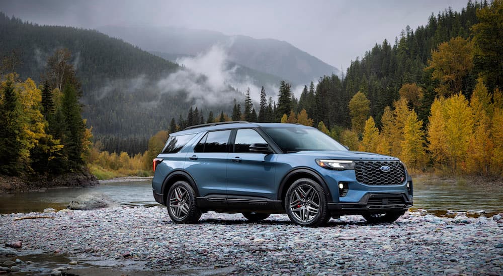 A blue 2025 Ford Explorer ST is shown from the side while parked off-road.