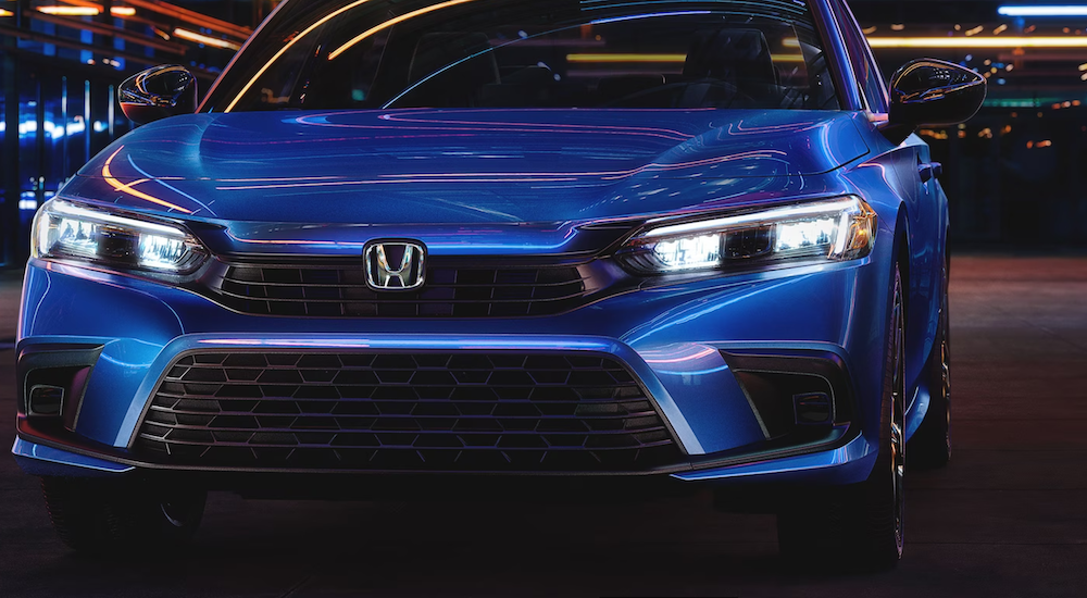 A close-up on the hood and grille of a blue 2025 Honda Civic Hybrid.