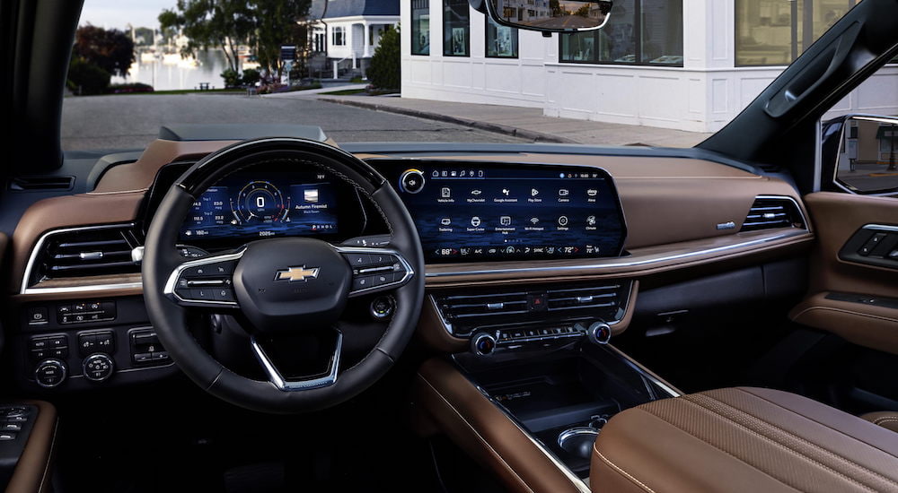 The brown interior of a 2025 Chevy Suburban for sale is shown from the driver's seat.