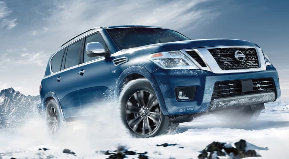 A blue 2020 Nissan Armada is shown from the front at an angle while driving through snow.