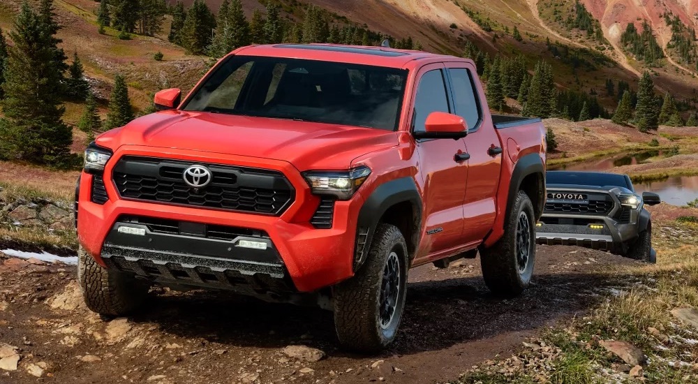 A red 2024 Toyota Tacoma TRD off-roading after visiting a Toyota dealer.