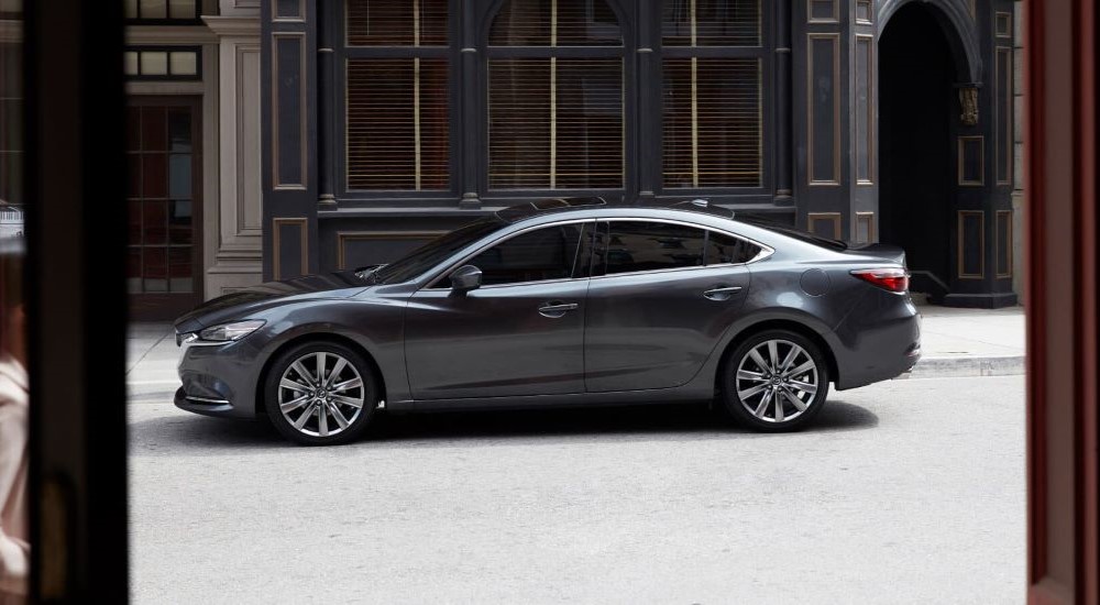 A gray 2019 Mazda6 is shown parked near a city curb.