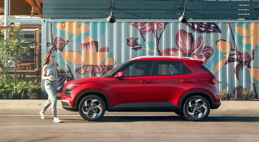 A red 2024 Hyundai Venue Limited is shown parked near a mural on a wall.