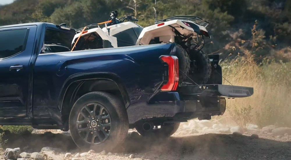 An ATV loaded in the bed of a blue 2024 Toyota Tundra Platinum.