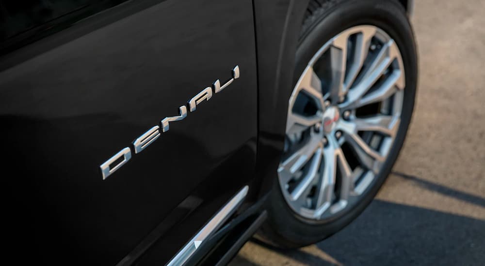 A close-up on the Denali badging of a black 2024 GMC Yukon Denali.