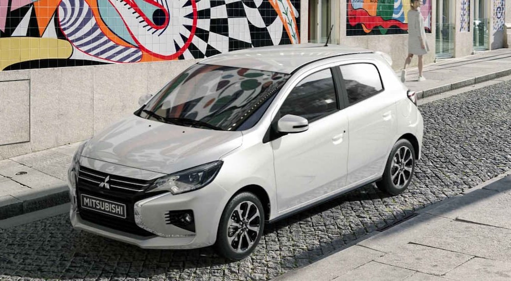 A white 2024 Mitsubishi Mirage is shown parked on a city street.