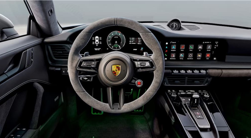 A close-up on the black dash of a 2025 Porsche 911 Carrera GTS Hybrid is shown.