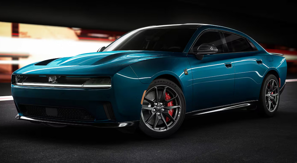 A deep blue 2024 Dodge Charger Dayton Scat Pack parked in a garage.